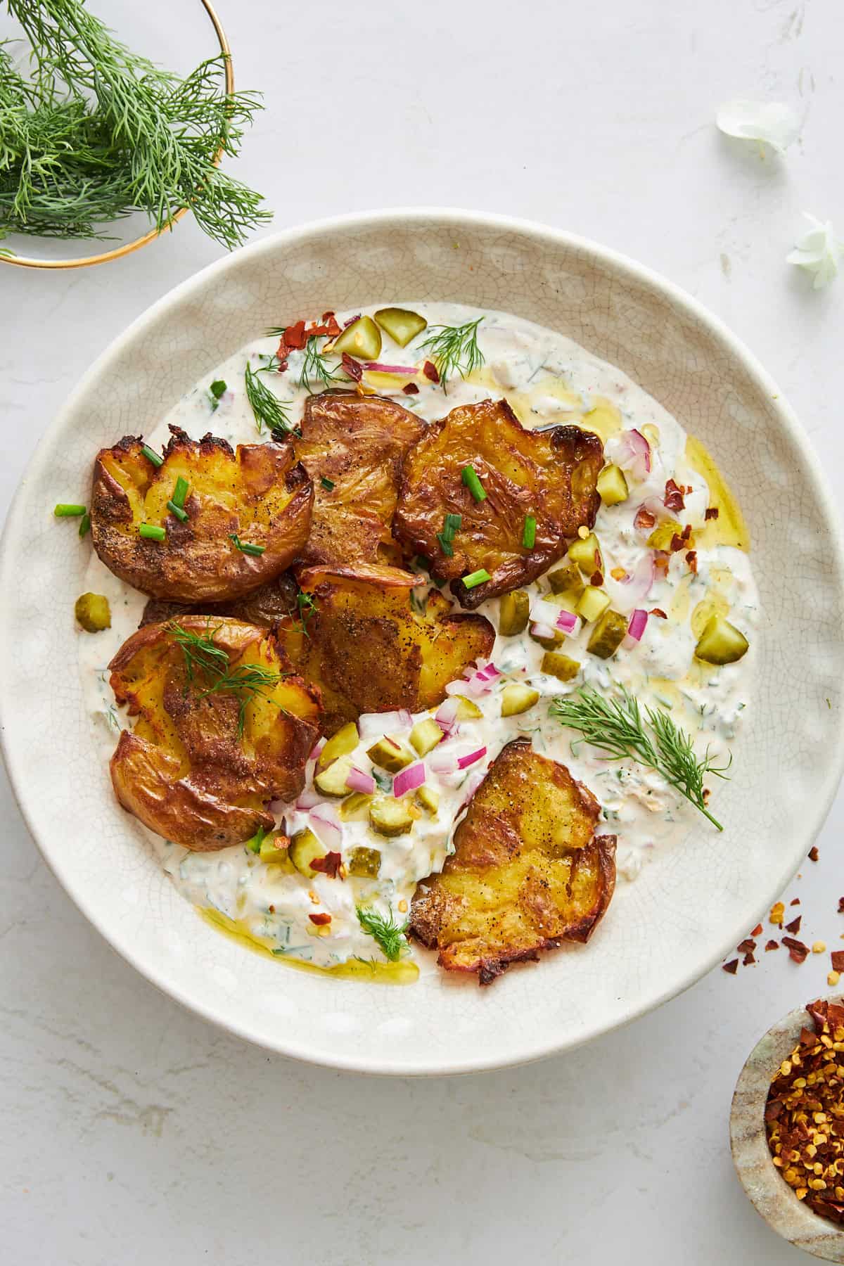 A bowl of labne topped with crispy potatoes. 