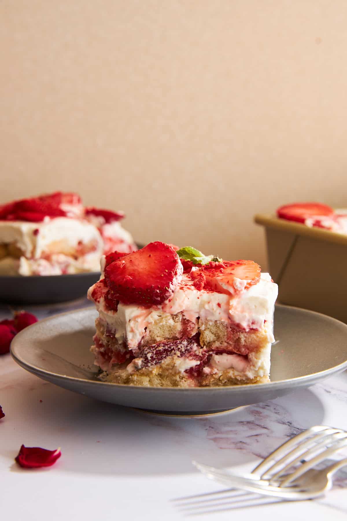 Slices of strawberry tiramisu on plates. 