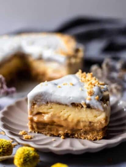 a side view of a slice of banofee pie showing layers of crust, dulce de leche, pudding, and cream