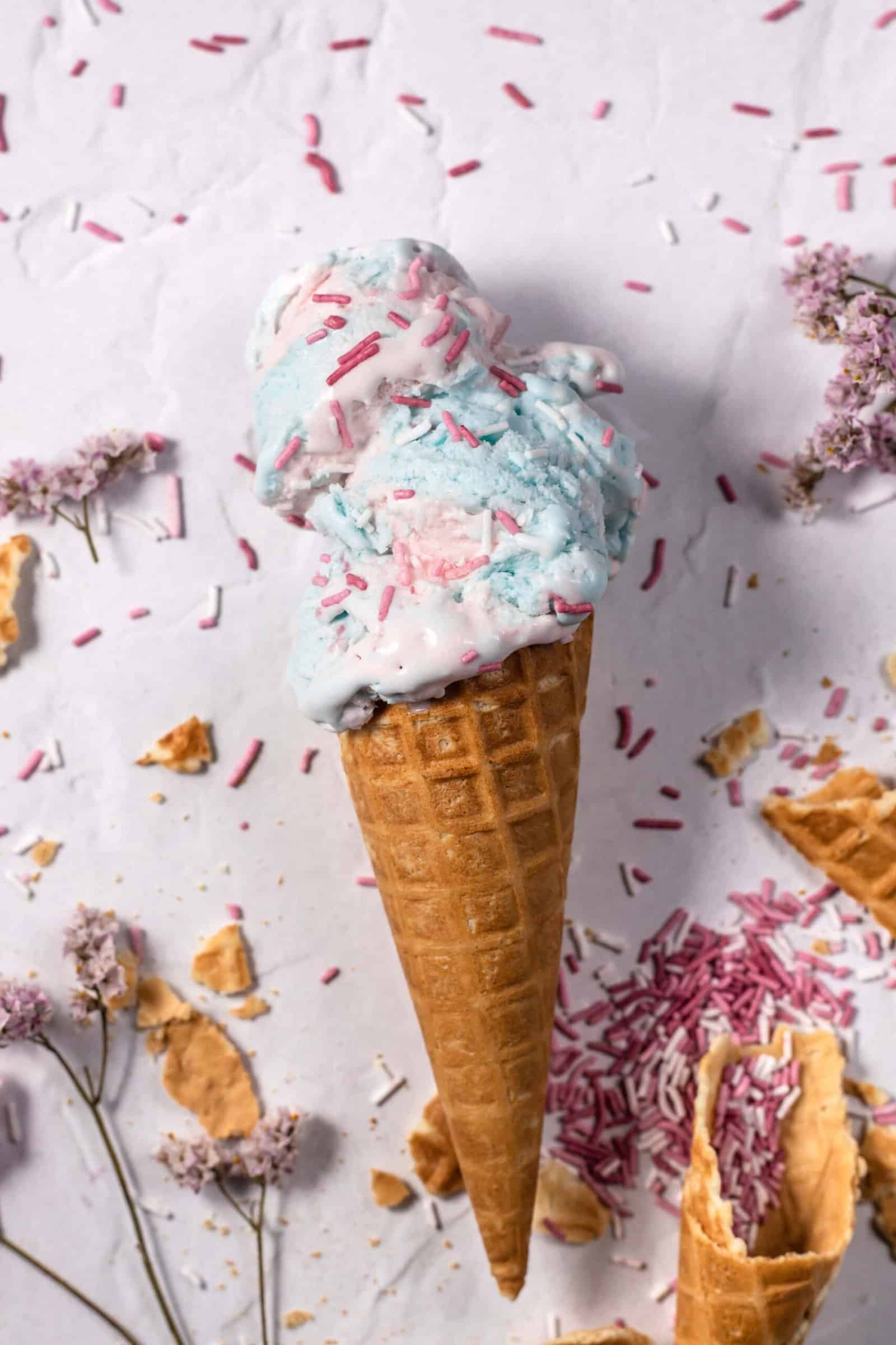 Delicious Pink Ice Cream with Sprinkles in a Waffle Cone on Blue