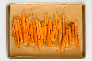 Seasoned carrots on a baking dish.