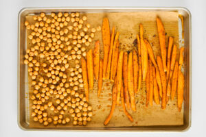 Carrots and chickpeas on a baking sheet.