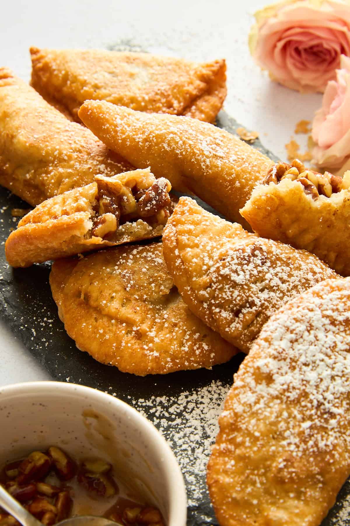 Fried pecan pies dusted with powdered sugar.