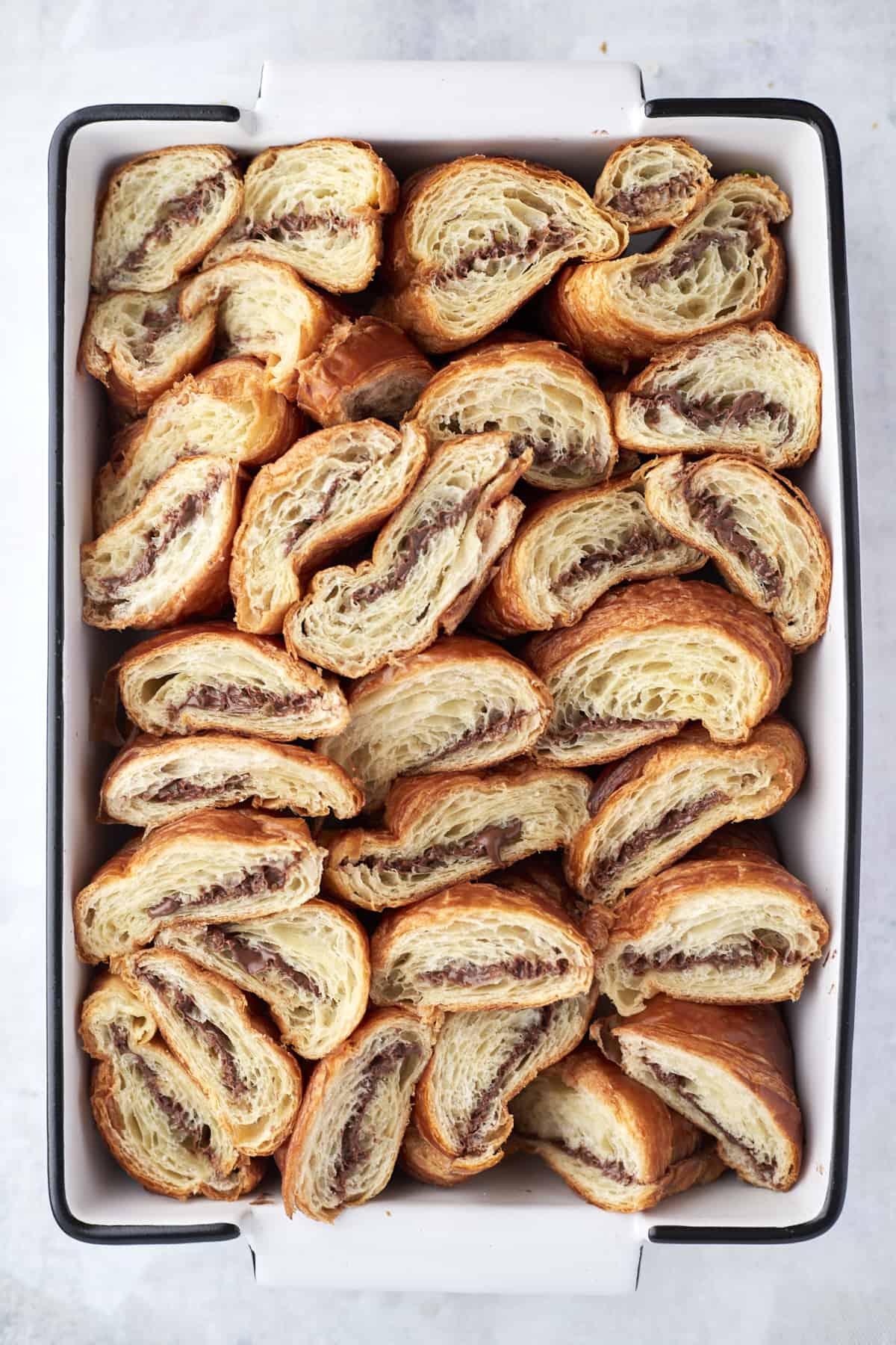 Freshly baked croissants with nutella on a white plate near