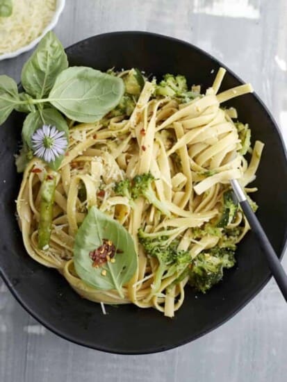 overhead image of a black bowl of pasta with veggies