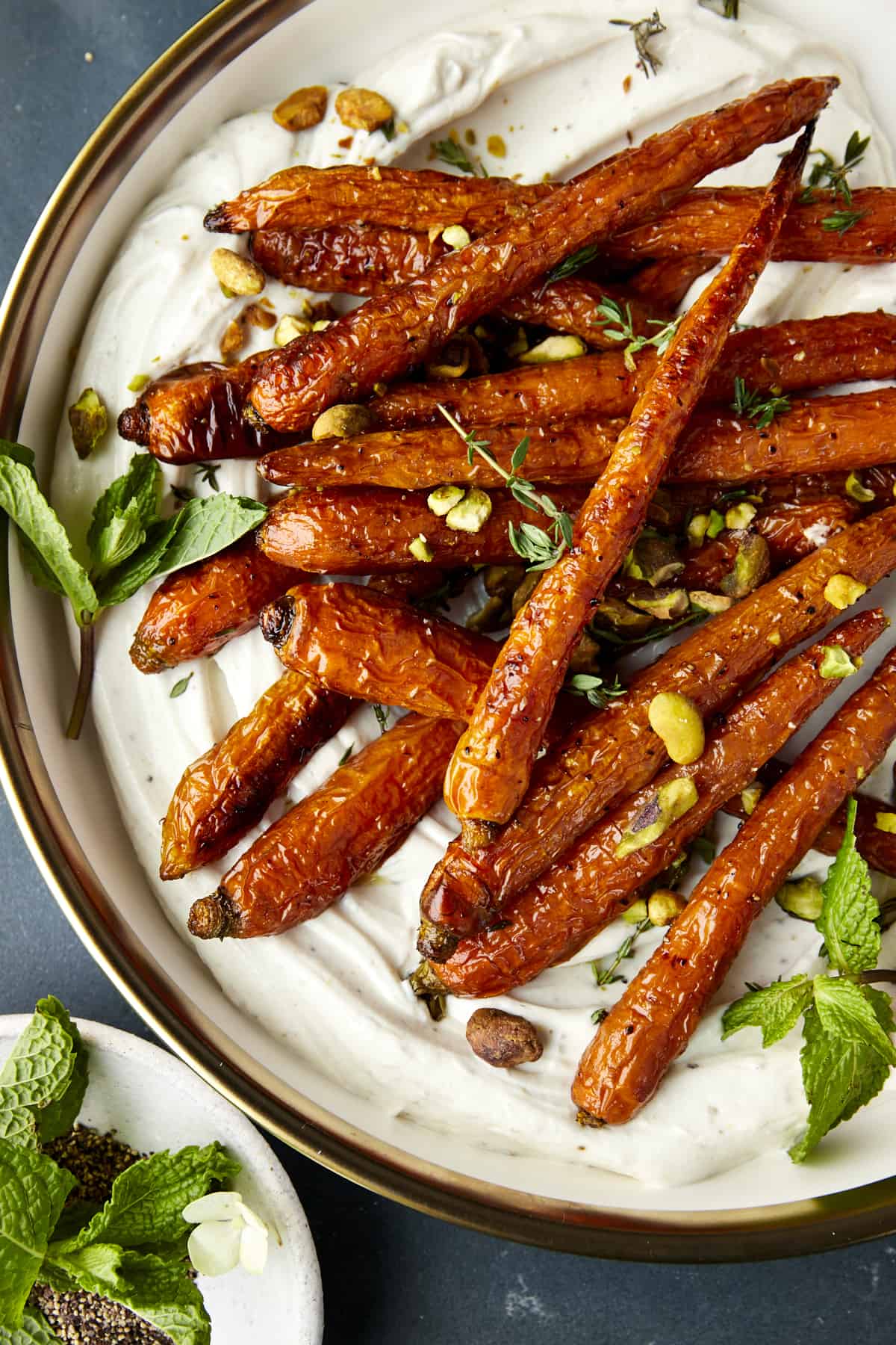 Oven roasted carrots with tahini dressing topped with mint and pistachios.