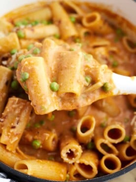 a spoon lifting a bite of one pot spicy rigatoni from a pot