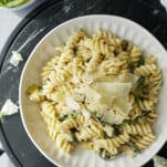 a plate of one pot spinach and artichoke pasta topped with Parmesan flakes