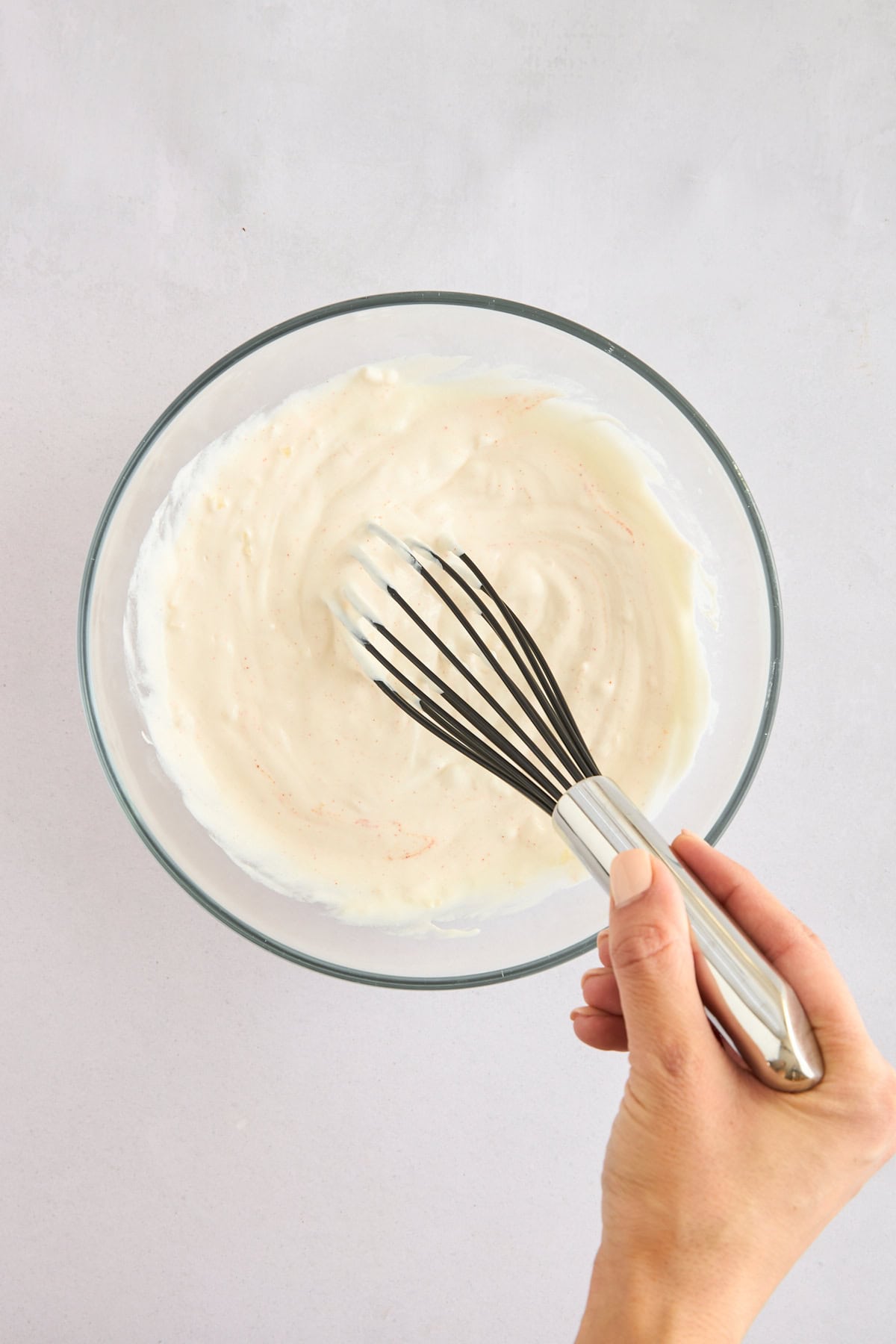 Garlic yogurt sauce being whisked. 