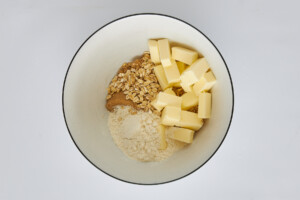 Butter, flour, oats, and cinnamon in a bowl.