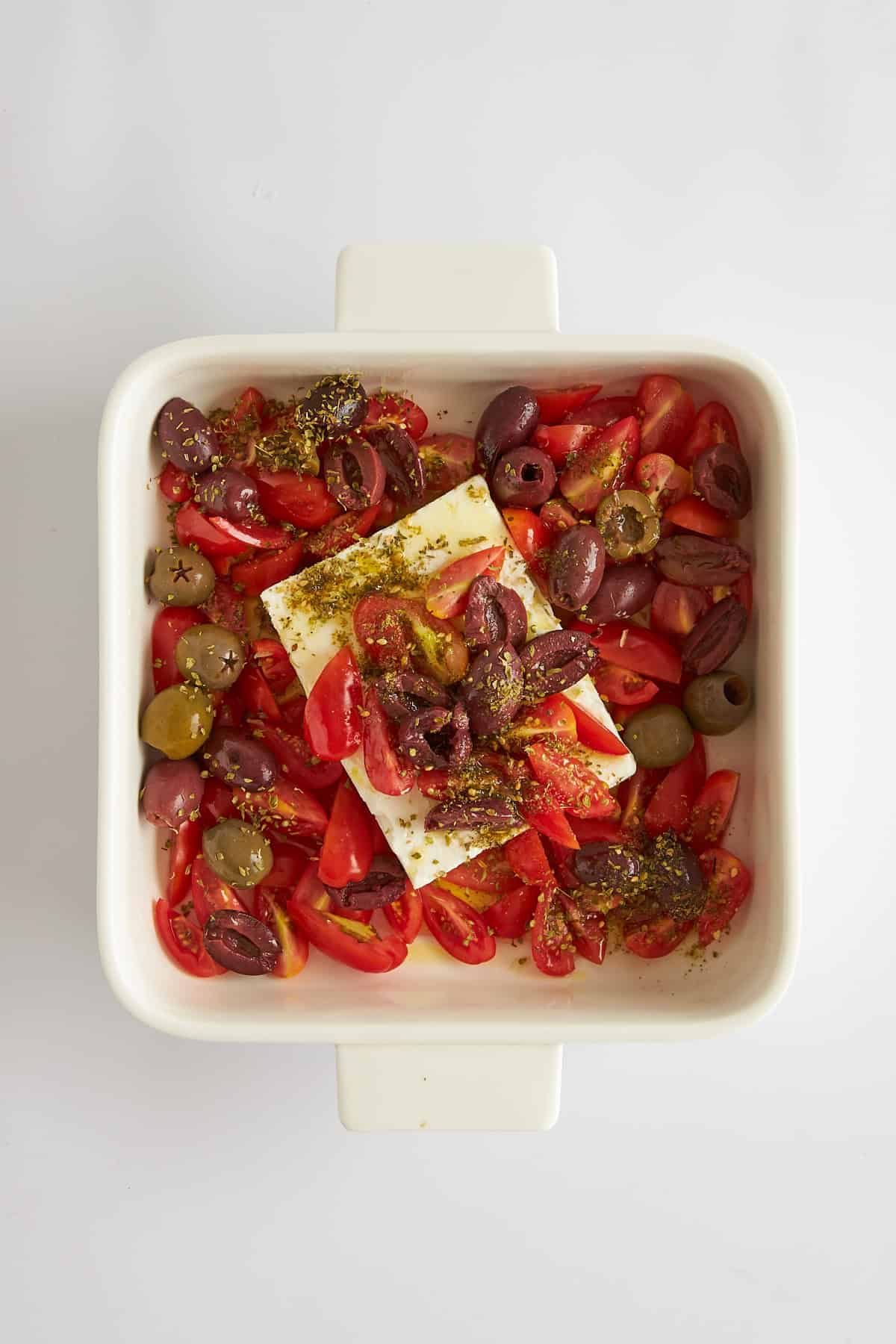 Unbaked feta dip in a square dish. 