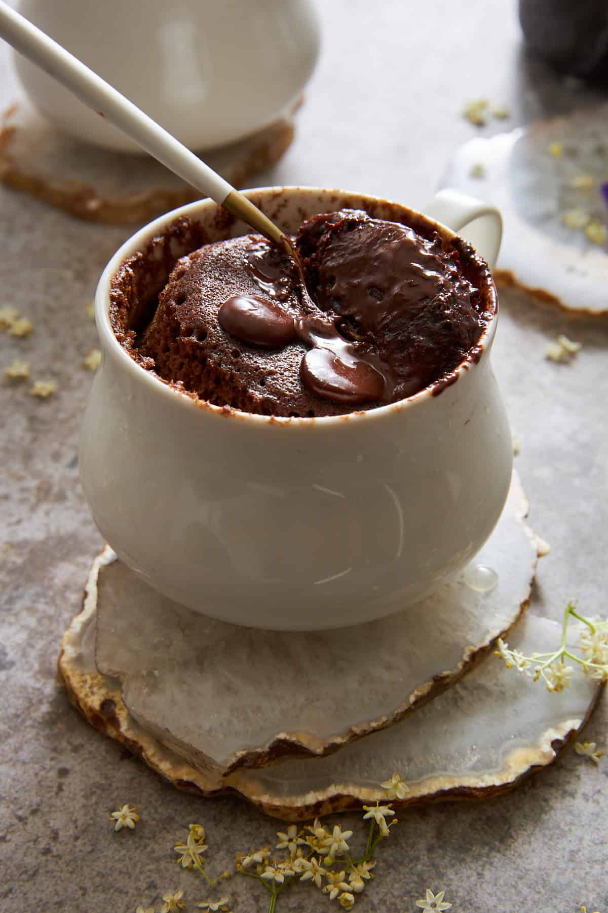 A spoon sinking into a chocolate mug cake. 