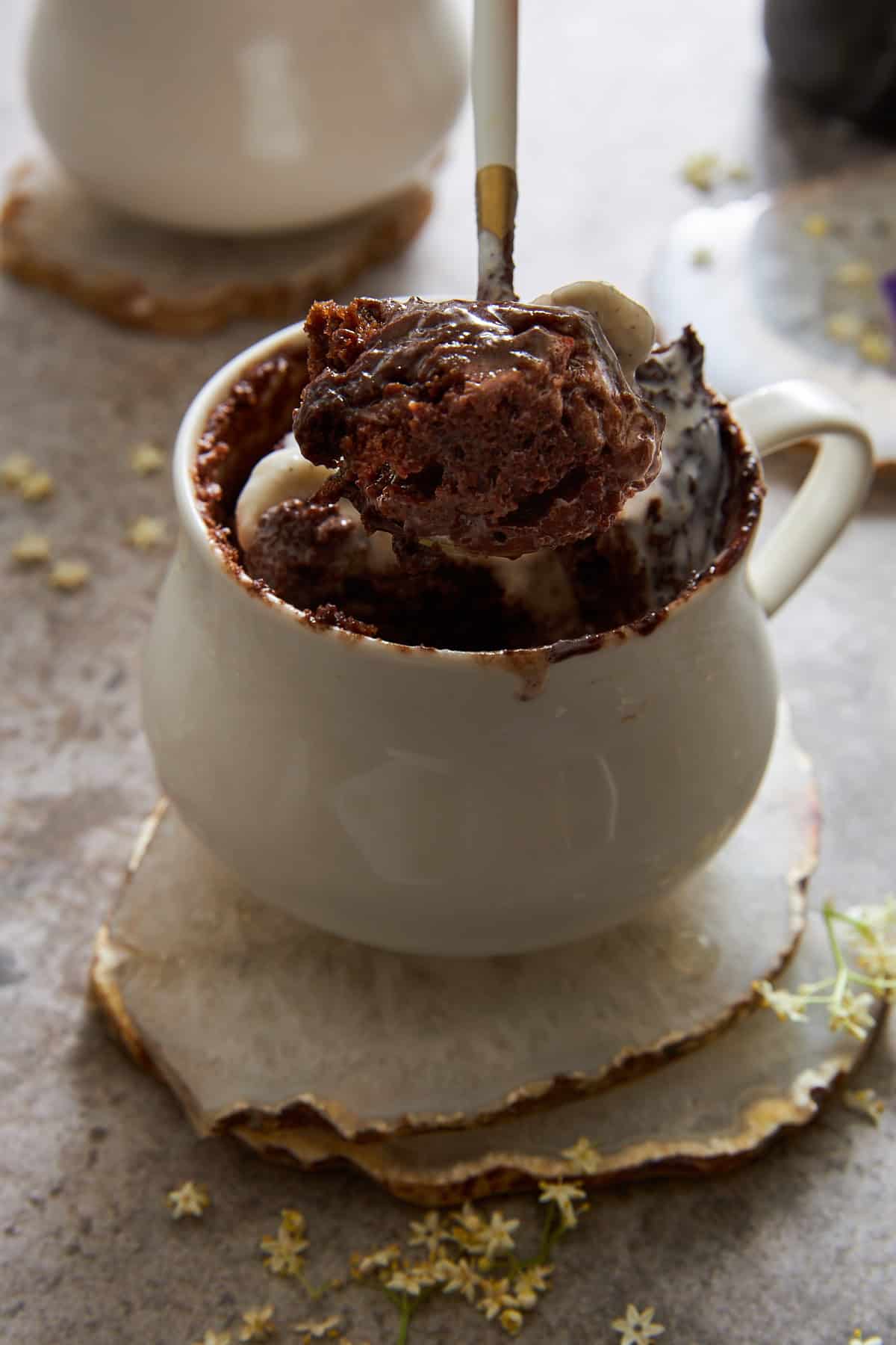 A spoon lifting a bite of chocolate mug cake. 