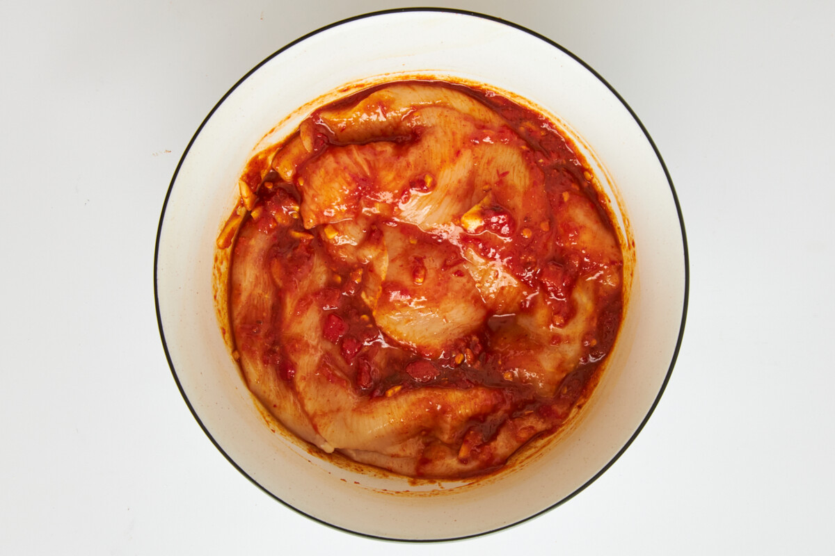 Chicken marinading in honey harissa sauce.