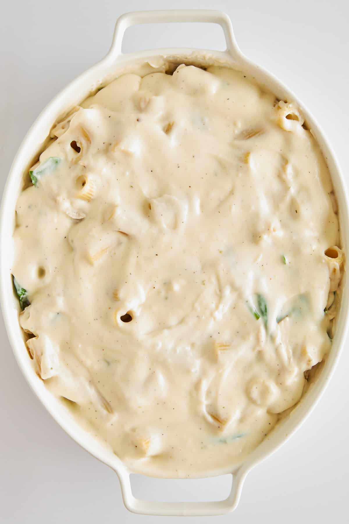 Uncooked Chicken Spinach Pasta Bake in a baking dish. 