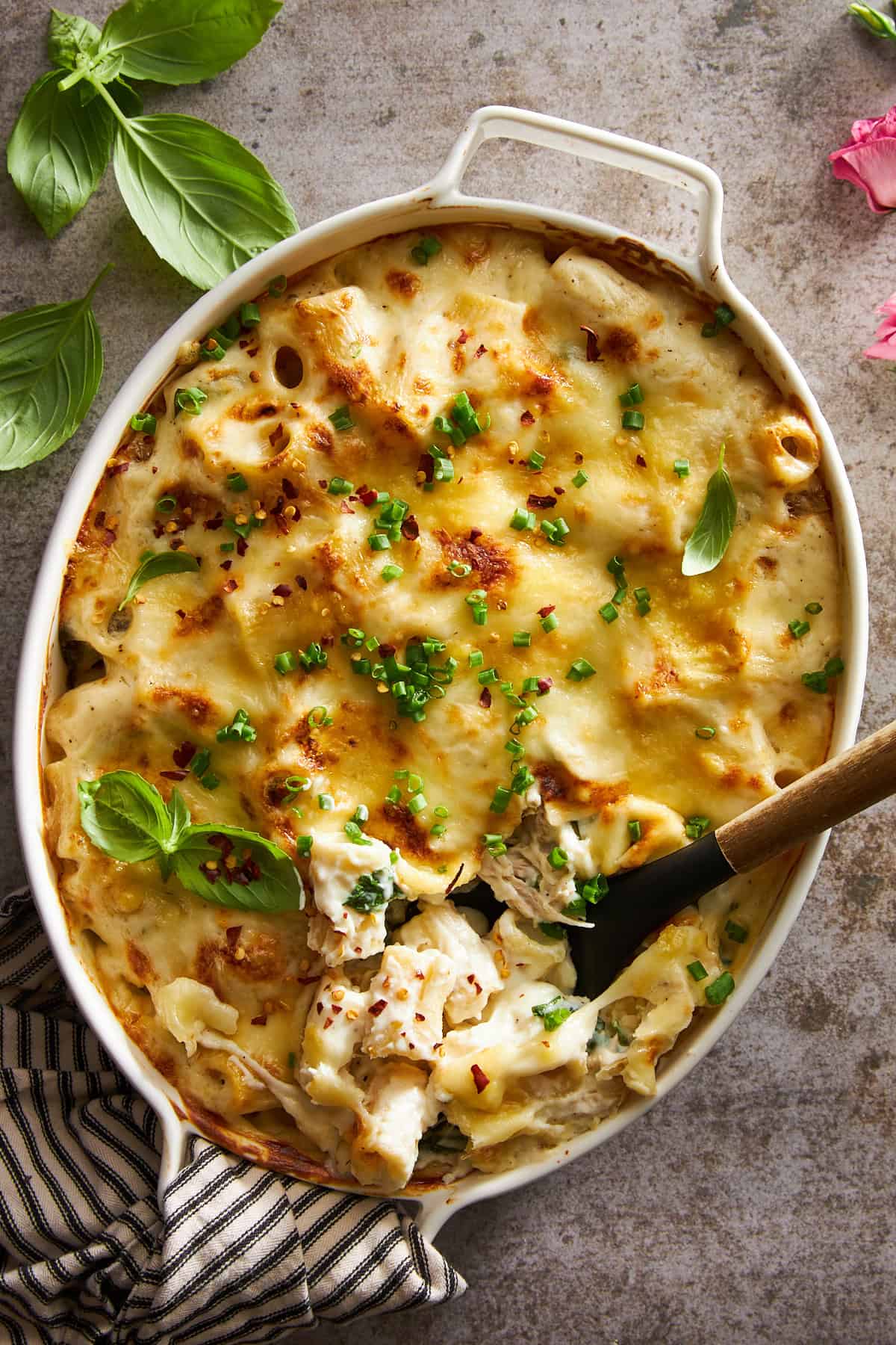 Overhead image of a chicken spinach pasta bake with a spoon sunk in. 