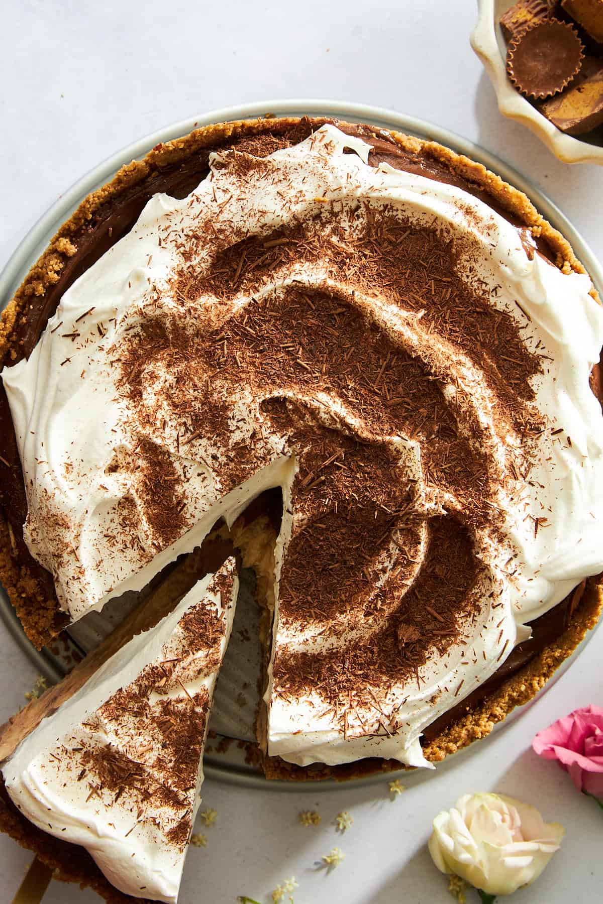 A slice of no-bake chocolate peanut butter pie being lifted from the cake. 