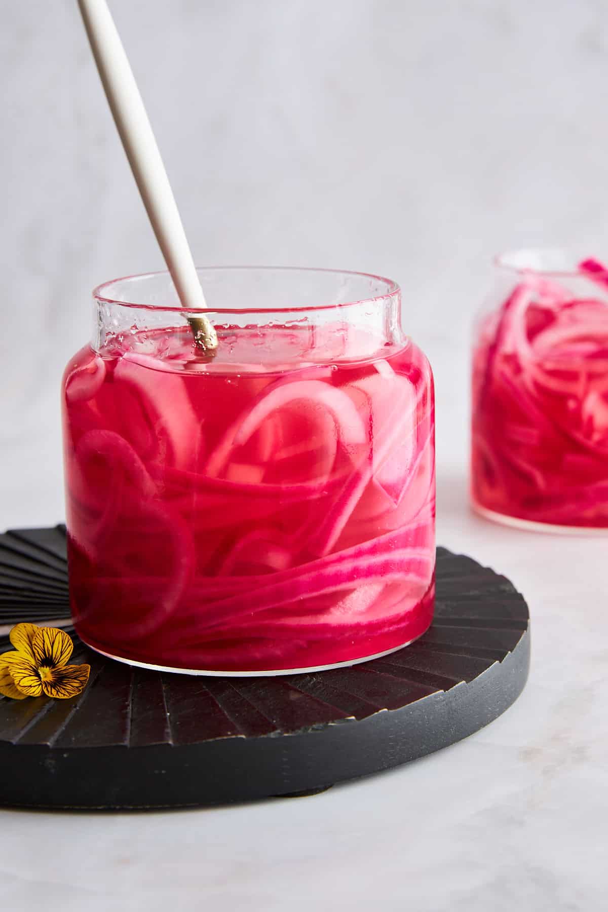 A jar of pickled red onions with a fork sticking out. 