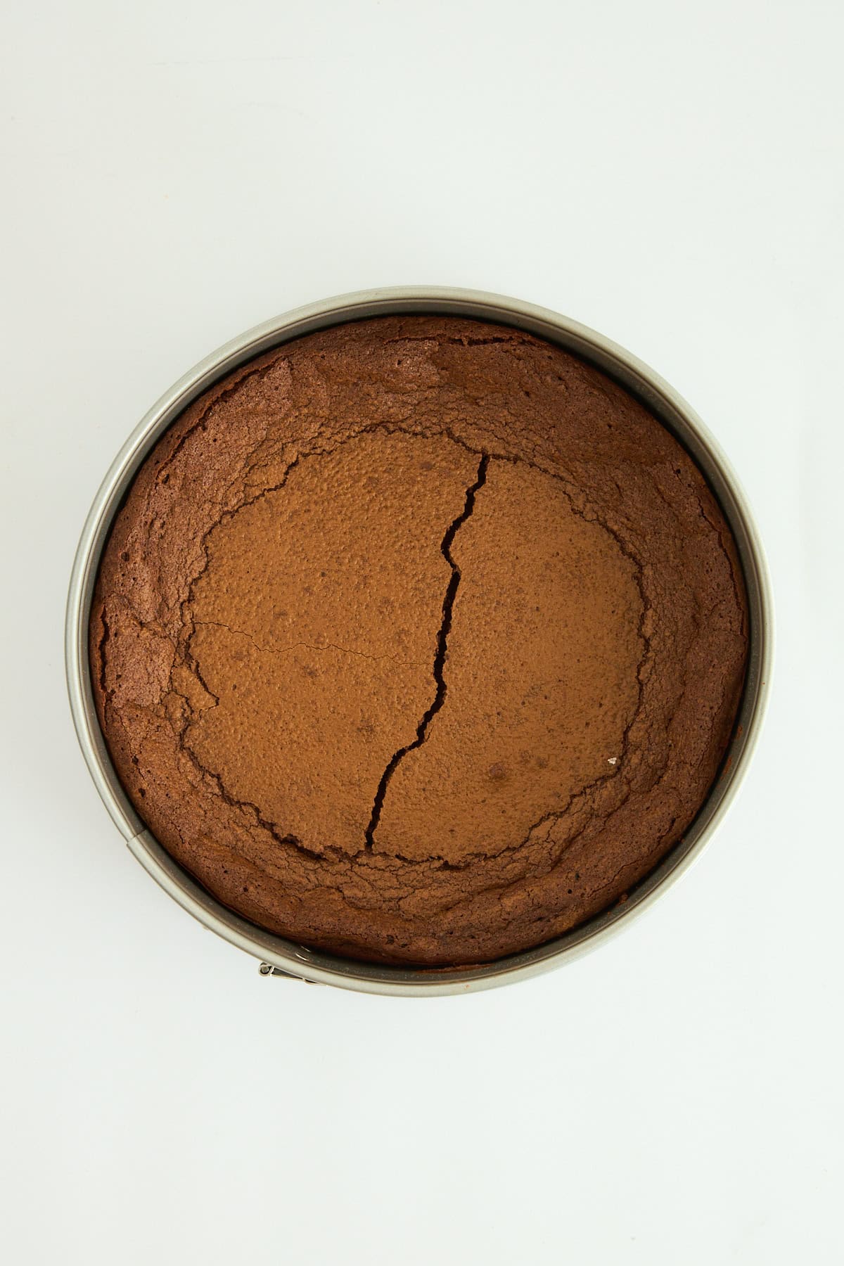 A flourless chocolate cake in a cake pan. 