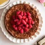 Overhead image of a flourless chocolate cake topped with raspberries.