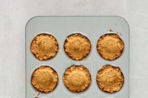 Baked granola cups in a muffin tin.