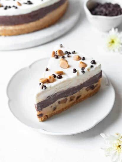 slice of chocolate peanut butter pie on a plate with chocolate chips and peanut butter chips.