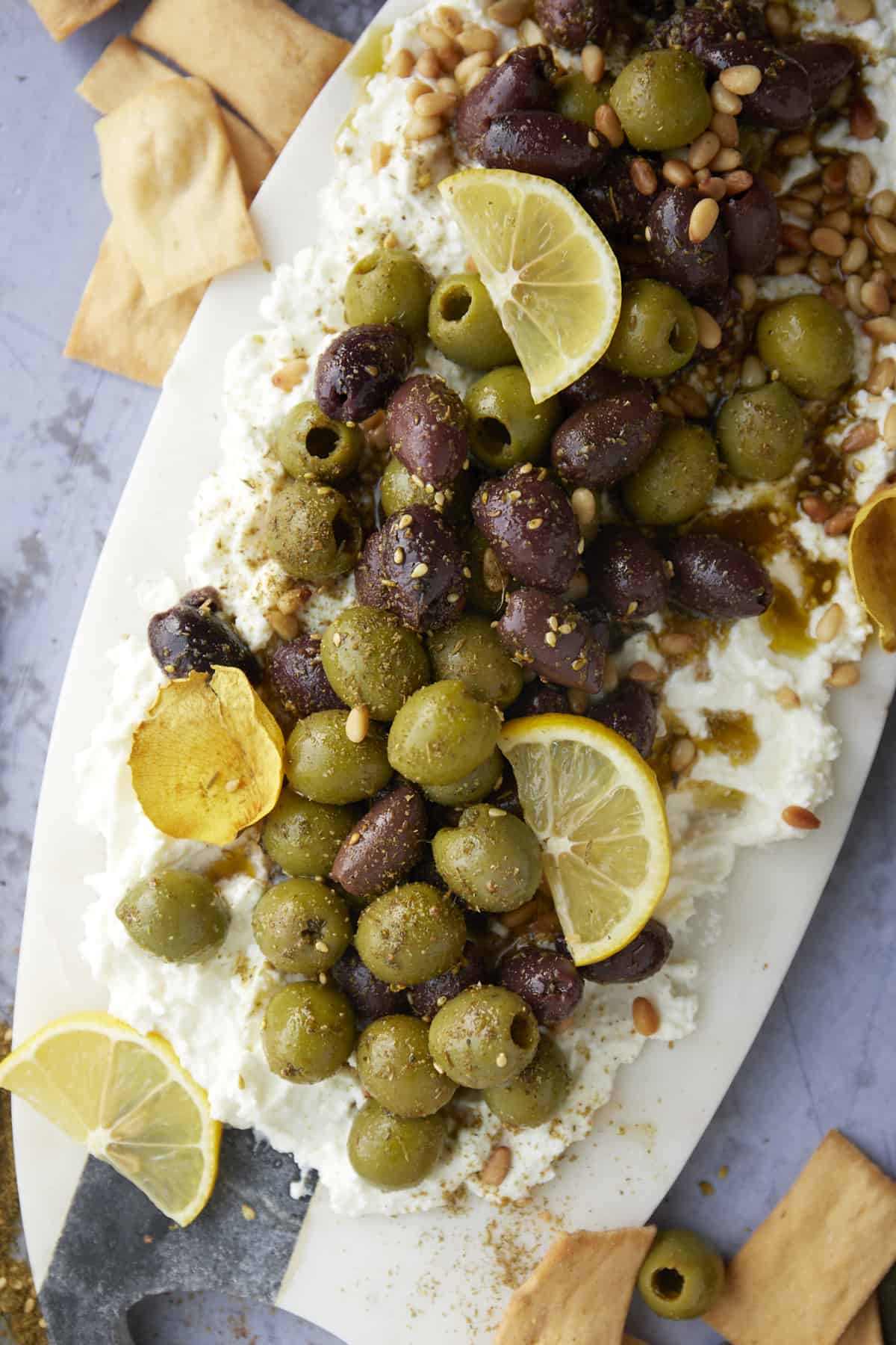 overhead image of a feta board topped with marinated olives