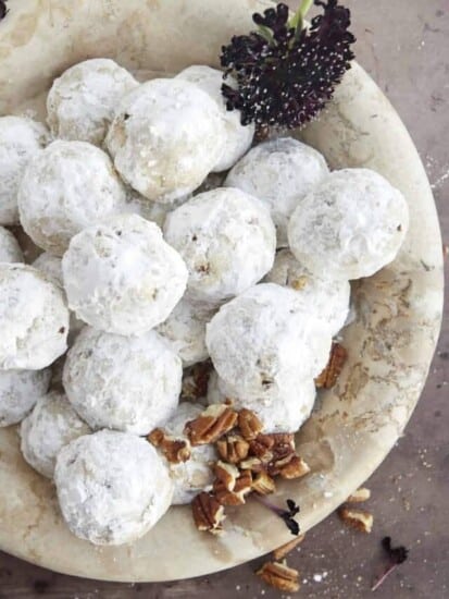 a bowl of pecan snowball cookies with pecans in the bottom