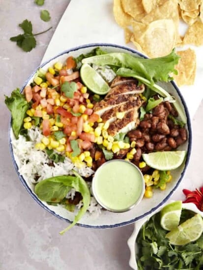 a bowl of southwest chicken salad with creamy yogurt dressing on the side