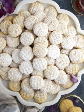 A platter of plain kahk cookies dusted with powdered sugar.