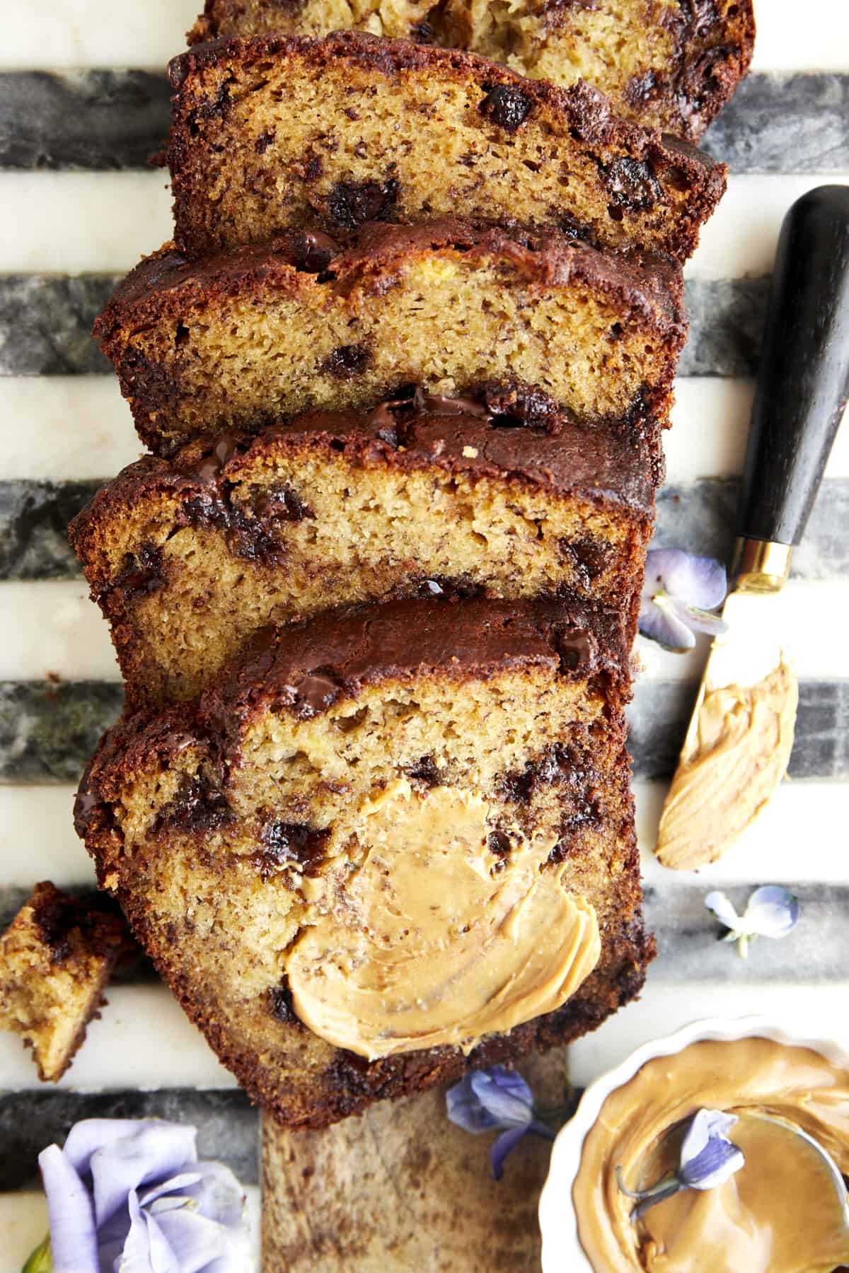 Chocolate chip peanut butter banana bread with peanut butter smeared over the top piece.