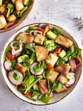 A bowl of fattoush salad topped with pita chips.