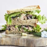 Two halves of a Mediterranean tuna salad sandwich stacked on top of each other.