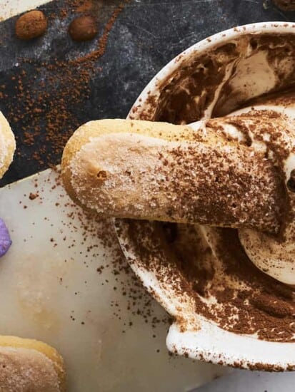 A bowl of tiramisu dip with a ladyfinger sticking out.