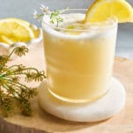 A glass of creamy lemonade with a lemon wedge on top.
