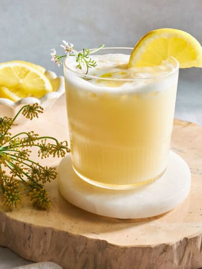 A glass of creamy lemonade with a lemon wedge on top.