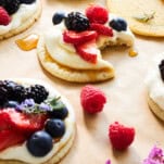 Fruit pizza cookies with one missing a bite.