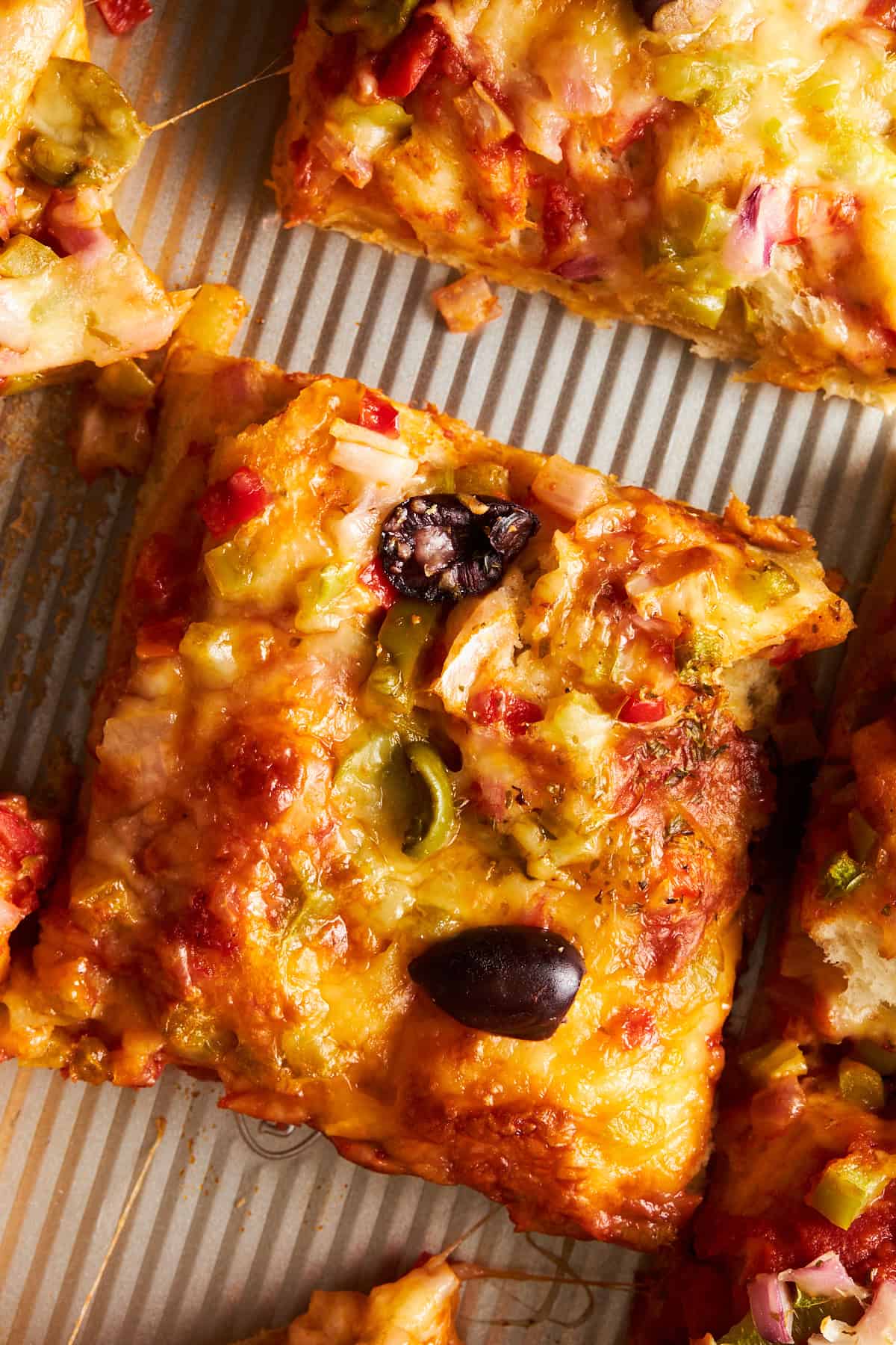 A slice of dinner roll sheet pan pizza. 