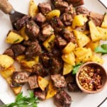 A plate of steak bites and potatoes.