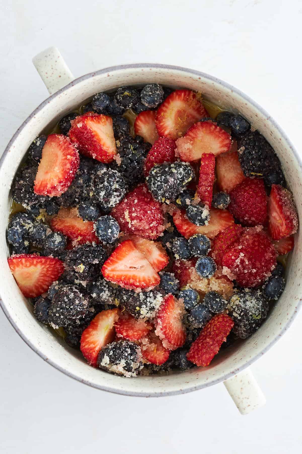 Mixed berry filling in a round bowl topped with sugar. 