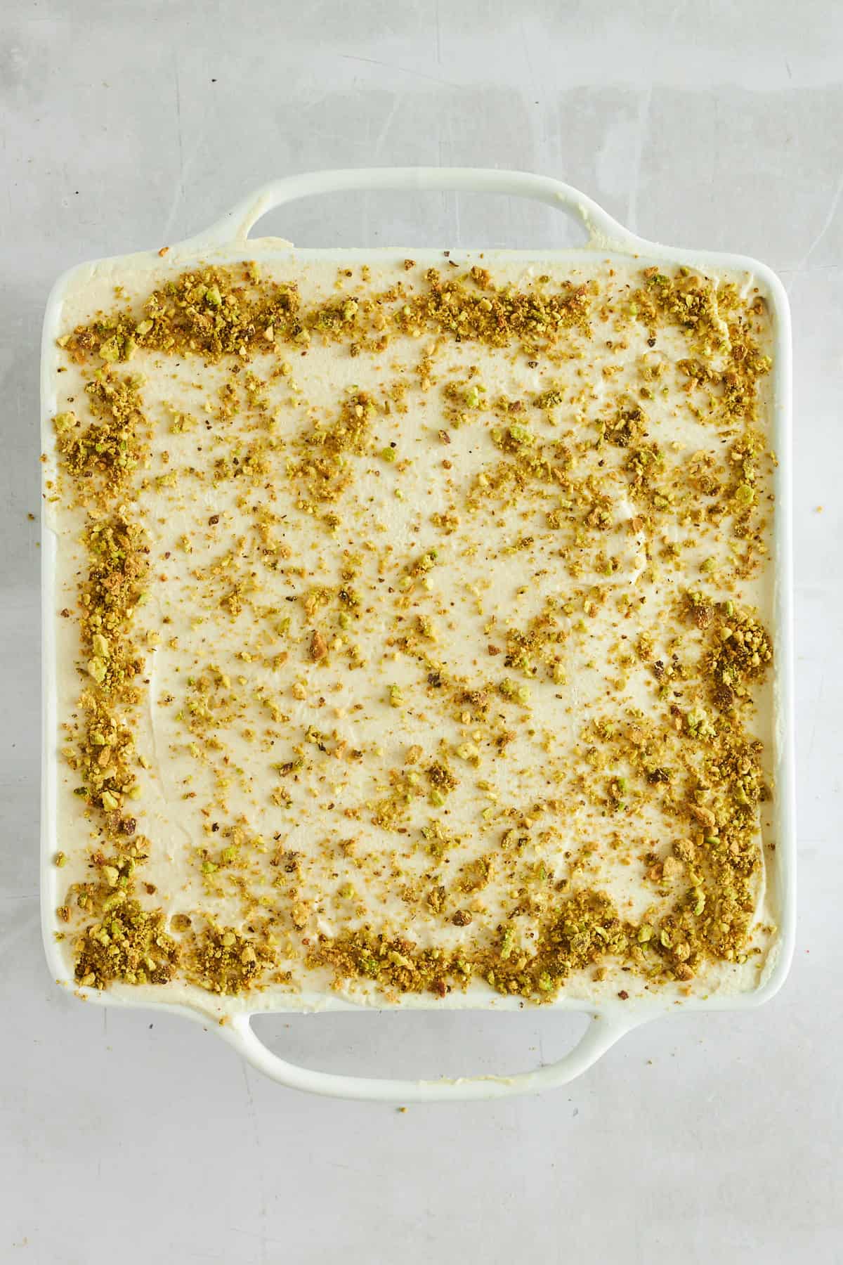 A square baking dish of pistachio tiramisu. 