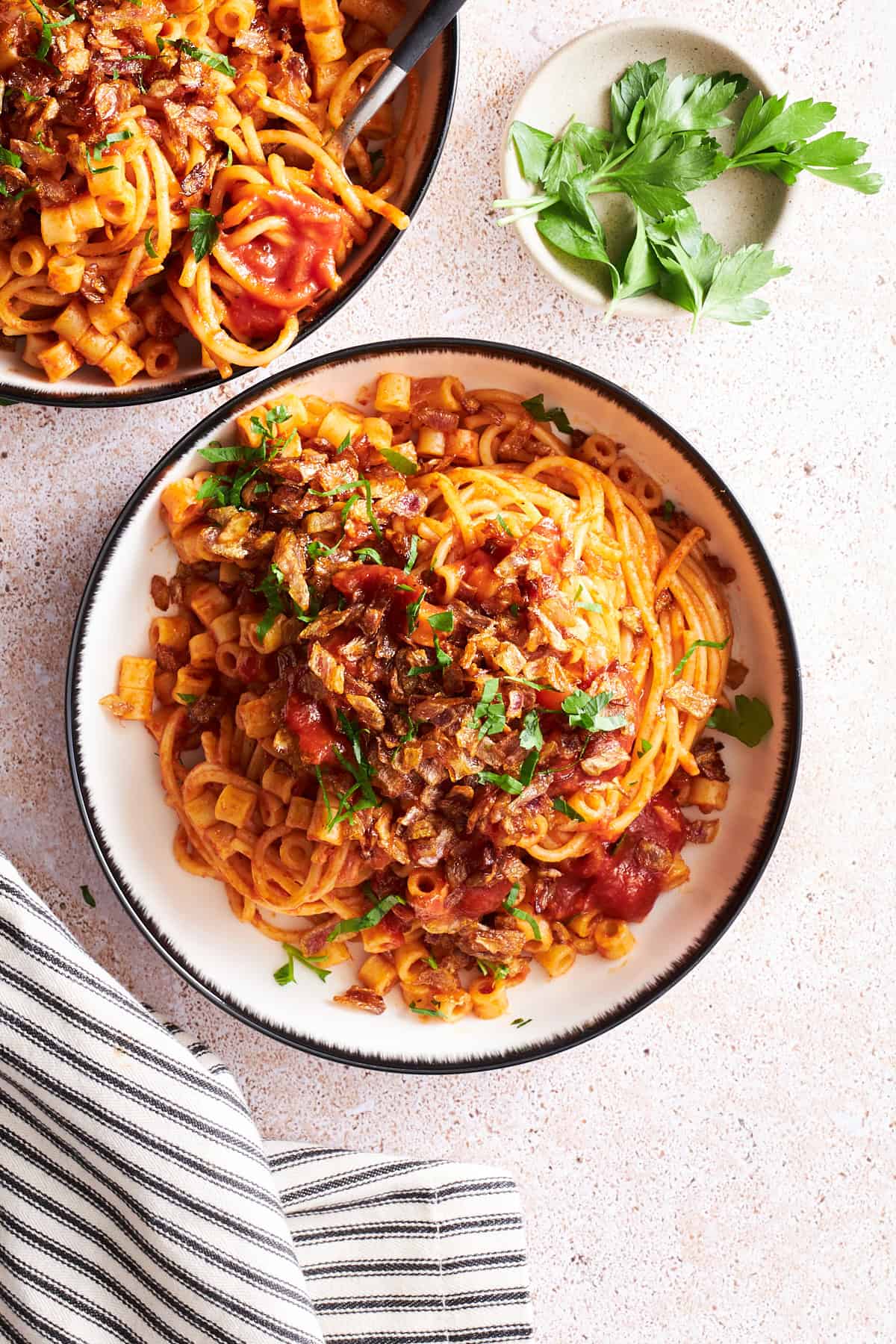 Overhead image of two bowl of koshary Egyptian pasta. 