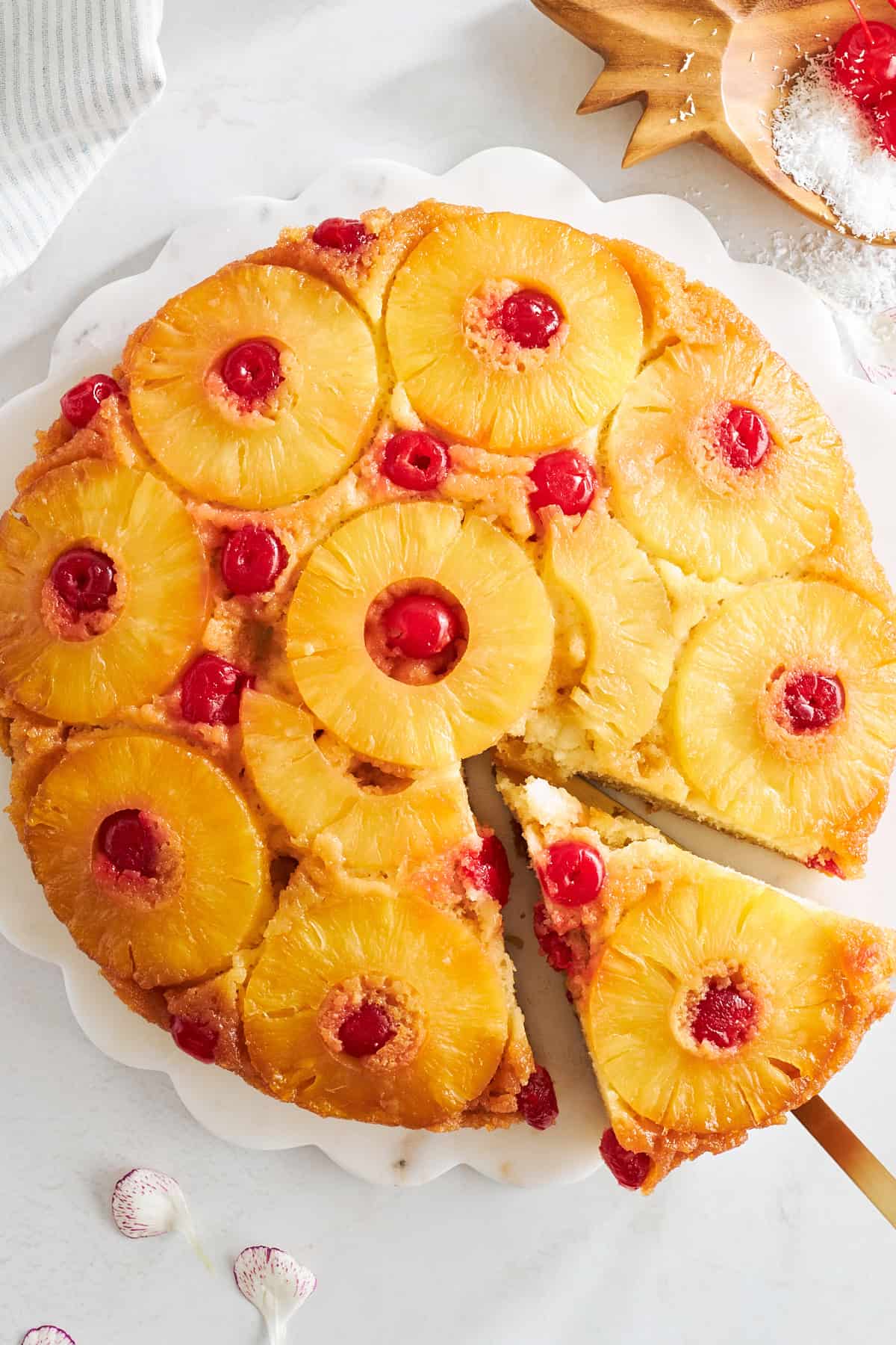 A slice of pineapple upside down cake being removed from a whole cake. 