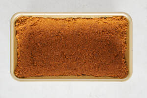 Biscoff crust pressed into a loaf pan.