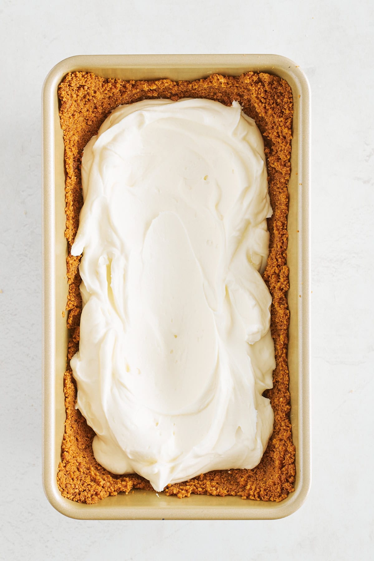 Cheesecake filling pressed into a Biscoff cookie crust in a loaf pan. 