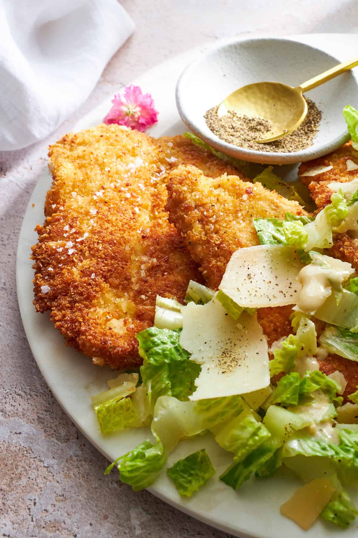 A plate of chicken Milanese with Caesar salad. 
