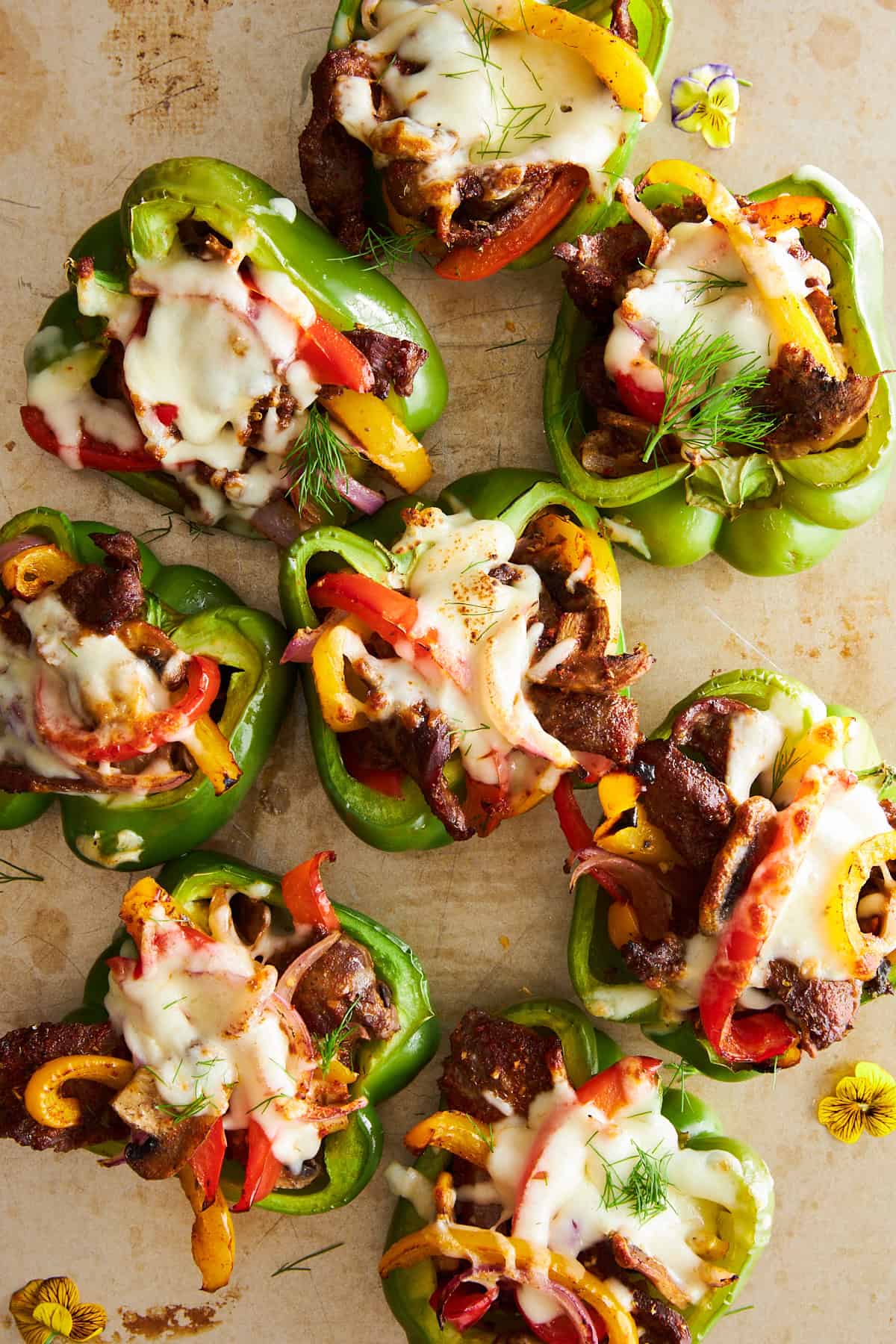 Philly cheesesteak stuffed peppers on a baking sheet. 