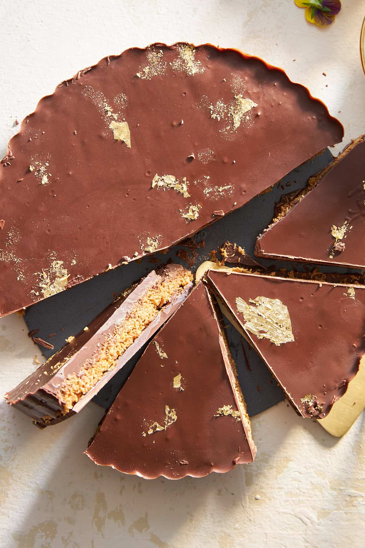 A chocolate peanut butter kunafa with four pieces sliced. 