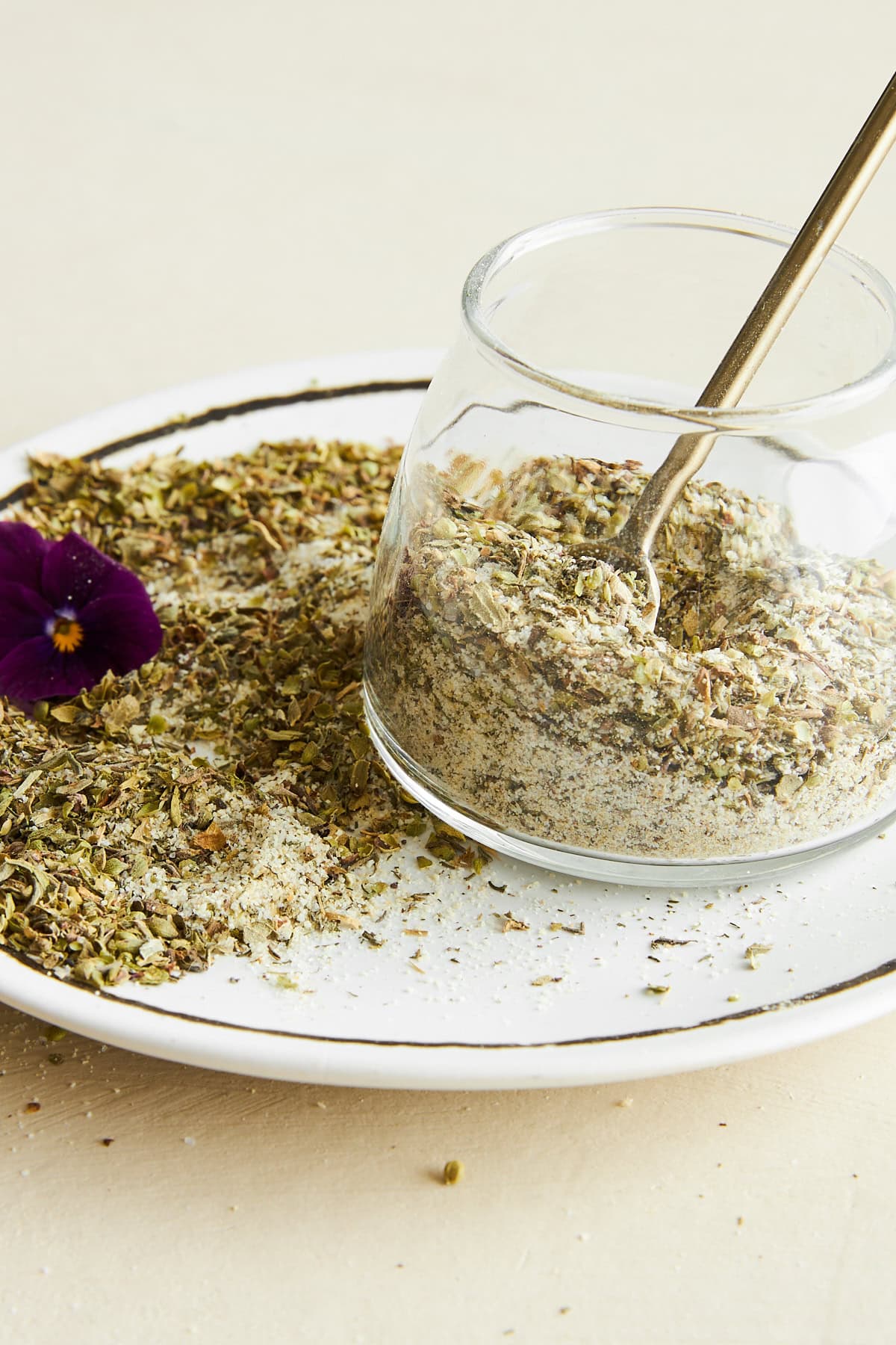 A jar of Greek seasoning on a plate.