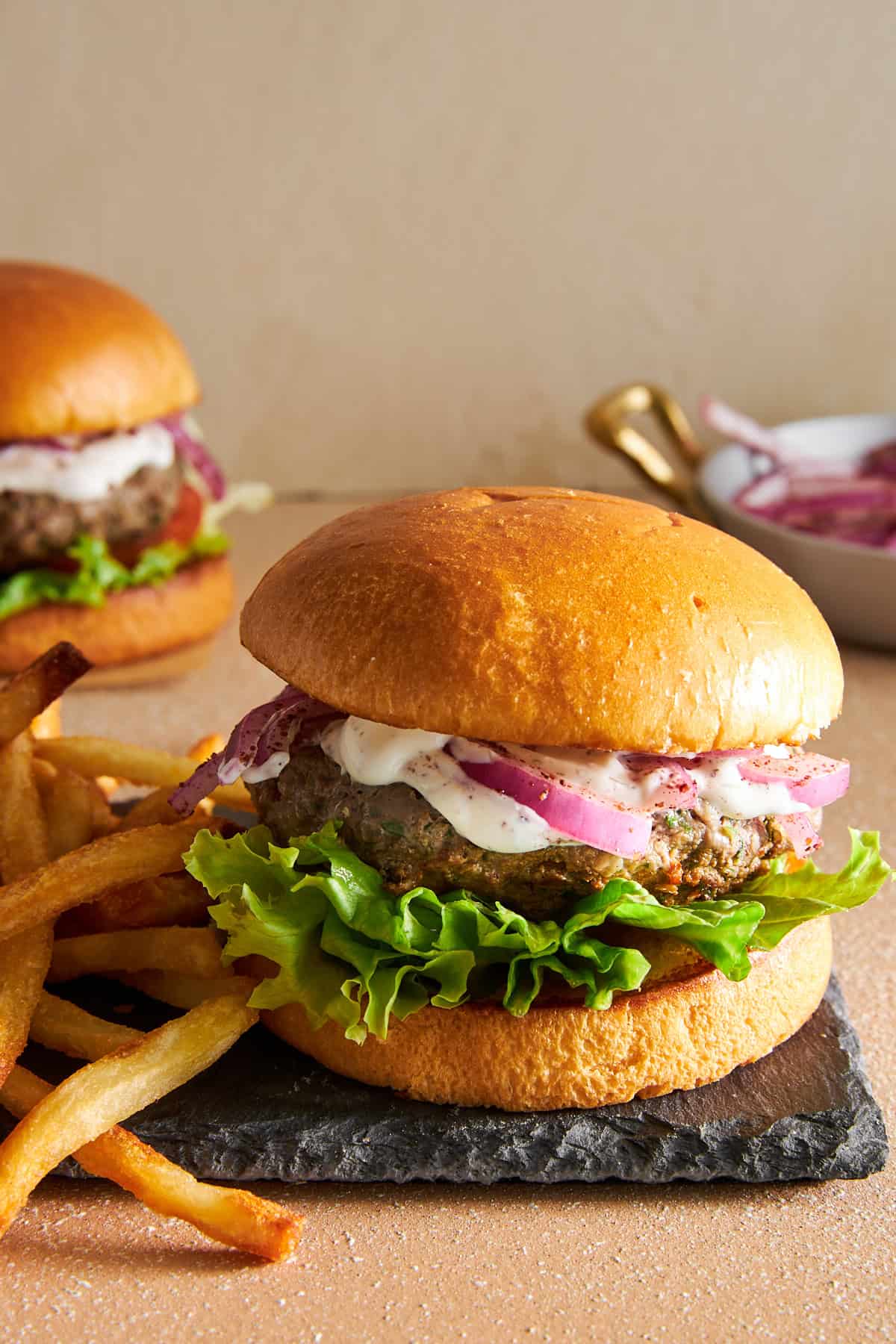 A lamb kofta burger on a plate with fries. 